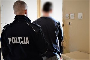 policjant prowadzi zatrzymanego