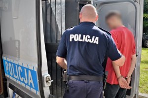 policjant prowadzi zatrzymanego