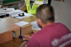 policjant przesłuchuje zatrzymanego