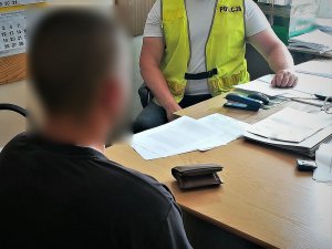 policjant przesłuchuje zatrzymanego