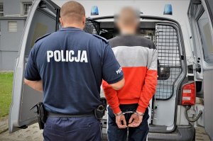 policjant prowadzi zatrzymanego