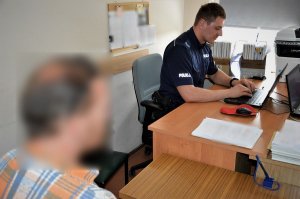policjant przesłuchuje zatrzymanego