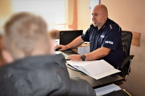 policjant przesłuchuje zatrzymanego