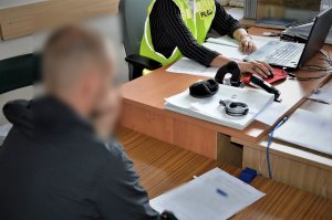 policjantka przesłuchuje zatrzymanego