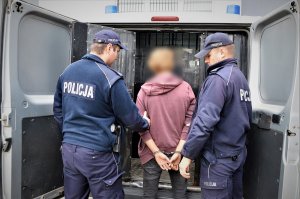 POLICJANCI DOPROWADZAJĄ ZATZRYMANEGO