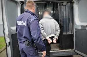 policjant doprowadza zatrzymanego