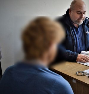 policjant przesłuchuje zatrzymanego