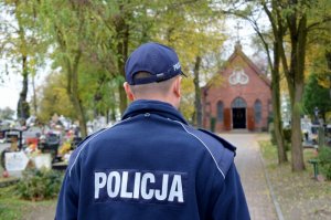 policjant stoi na cmentarzu