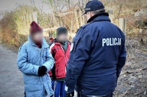 policjant rozmawia z osobami bezdomnymi