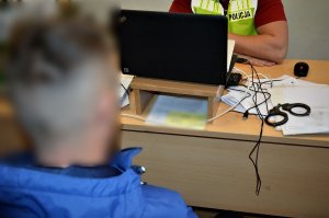 policjant przesłuchuje zatrzymanego