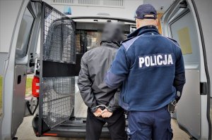 policjant doprowadza zatrzymanego