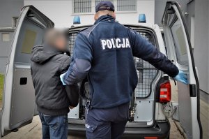 policjant doprowadza zatrzymanego