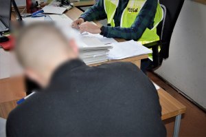 policjant przesłuchuje zatrzymanego