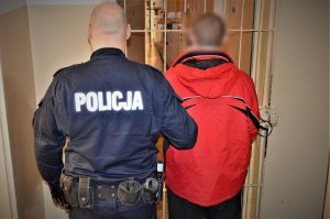 policjant doprowadza zatrzymanego