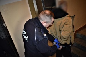 policjant doprowadza zatrzymanego