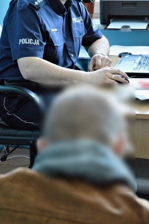 policjant przesłuchuje zatrzymanego