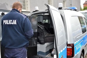 policjant doprowadza zatrzymanego