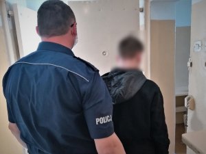 policjant doprowadza zatrzymanego