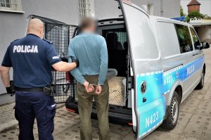 policjant doprowadza zatrzymanego