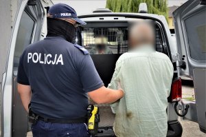 policjant doprowadza zatrzymanego