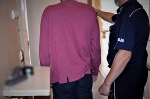 policjant doprowadza zatrzymanego