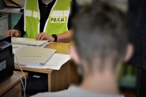 policjant przesłuchuje zatrzymanego
