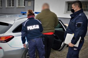 policjanci doprowadzają zatrzymanego
