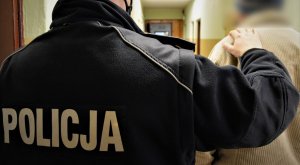 policjant doprowadza zatrzymanego