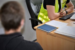 policjant przesłuchuje zatrzymanego