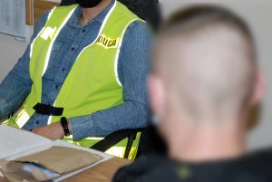 policjanci przesłuchują zatrzymanych