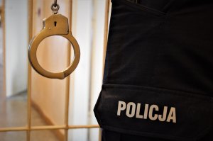 policjant trzyma kajdanki