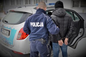 policjant doprowadza zatrzymanego