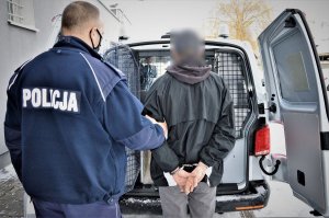 policjant doprowadza zatrzymanego