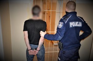 policjant doprowadza zatrzymanego