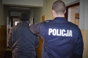 policjant doprowadza zatrzymanego