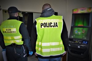 policjant i funkcjonariusz KAS zabezpieczają nielegalne automaty
