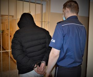 policjant doprowadza zatrzymanego