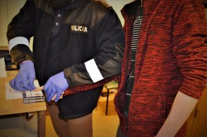 policjanci wykonują czynności z zatrzymanymi