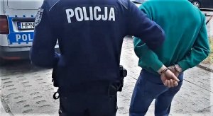policjanci doprowadzają zatrzymanego