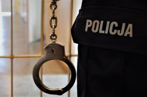 policjant trzyma kajdanki