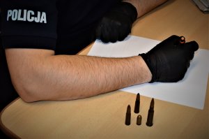 policjant wykonuje czynności z zatrzymanym
