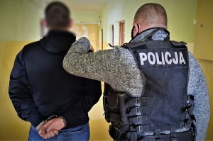 policjant doprowadza zatrzymanego