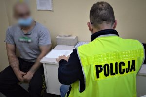 policjant przesłuchuje zatrzymanego