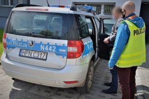 policjant doprowadza zatrzymanego