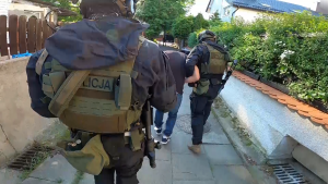 policjanci doprowadzają zatrzymanego