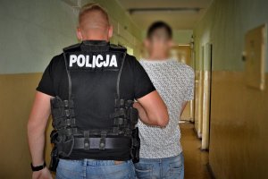 policjant doprowadza zatrzymanego