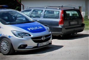 policjanci wykonują czynności przy odzyskanym samochodzie