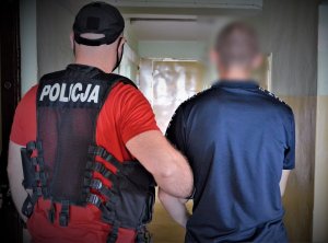 policjant doprowadza zatrzymanego