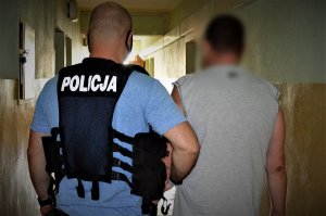 policjant doprowadza zatrzymanego