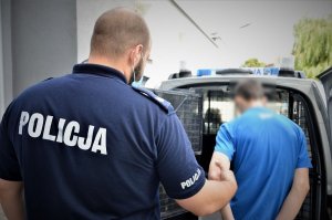 policjant doprowadza zatrzymanego